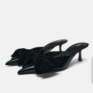 Adorable black kitten heels with a big bow on the front.